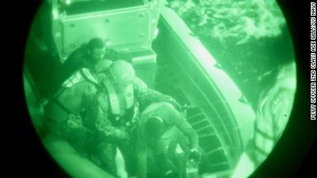 L’équipage de l’USCGC Glen Harris aide les migrants secourus à passer de leur petit bateau au cotre dans l’océan Atlantique.