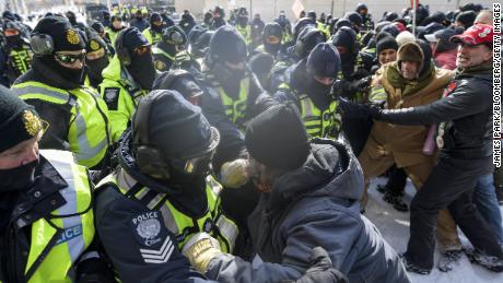 Des agents d’application de la loi affrontent des manifestants lors d’une manifestation à Ottawa vendredi.