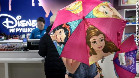 Un client ouvrant un parapluie mettant en vedette des princesses Disney aux Central Children’s Magasin sur la place Loubianka à Moscou en 2017.