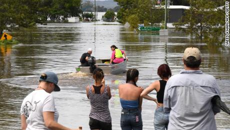 Des habitants se tiennent près d’une rue inondée dans la banlieue de Lawrence, à environ 70 kilomètres de la ville frontalière de la Nouvelle-Galles du Sud, Lismore, le 1er mars 2022. 