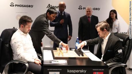 Pragg déplaçant une pièce d’échecs lors d’un match entre Ian Nepomniachtchi (à gauche) et Magnus Carlsen (à droite) au Championnat du monde d’échecs FIDE à l’EXPO 2020 Dubaï le 7 décembre 2021.