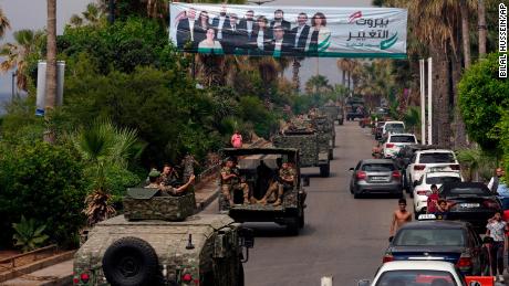 Des véhicules de l’armée libanaise passent devant un panneau d’affichage représentant les candidats aux élections parlementaires de dimanche à Beyrouth, au Liban, le 14 mai.