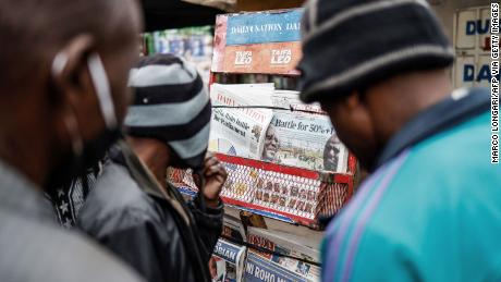 Les habitants regardent les journaux exposés sur un stand à Mathare, Nairobi, le 12 août 2022, après les élections générales au Kenya. 