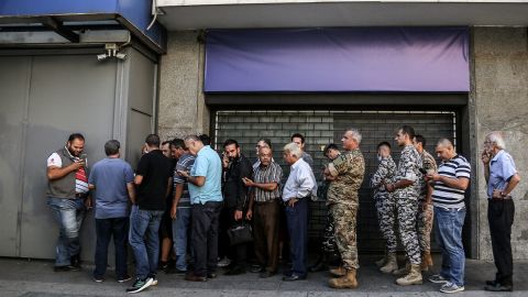 Des déposants libanais font la queue devant une banque locale fortifiée à Beyrouth. 