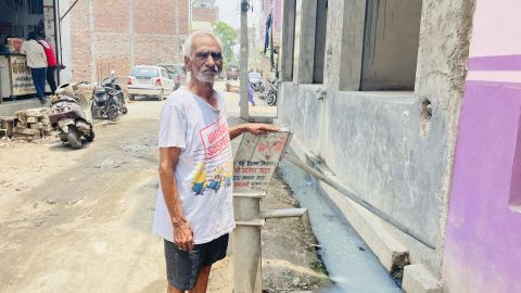 Jwala Prashad, 87 ans, à la pompe à main devant sa maison dans le village laitier de Bhalswa.