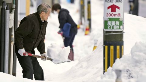 Des habitants pelletent la neige d’un trottoir à Kanazawa, dans la préfecture d’Ishikawa, au centre du Japon, le 24 décembre 2022.