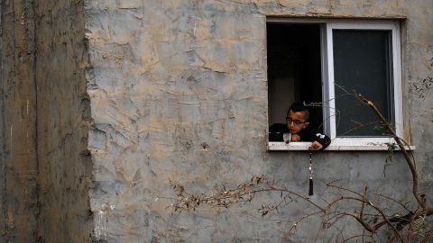 Un enfant joue près d’une fenêtre, à côté du bâtiment qui a été détruit.